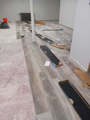 A spacious room featuring polished wood floors and a prominent, large wooden piece