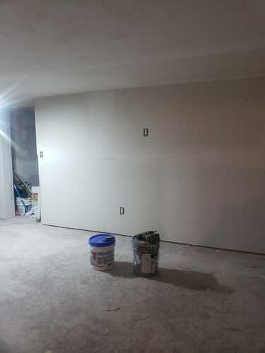 A room with a wall and ceiling in the process of being painted