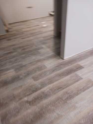 A spacious room featuring polished wood floors
